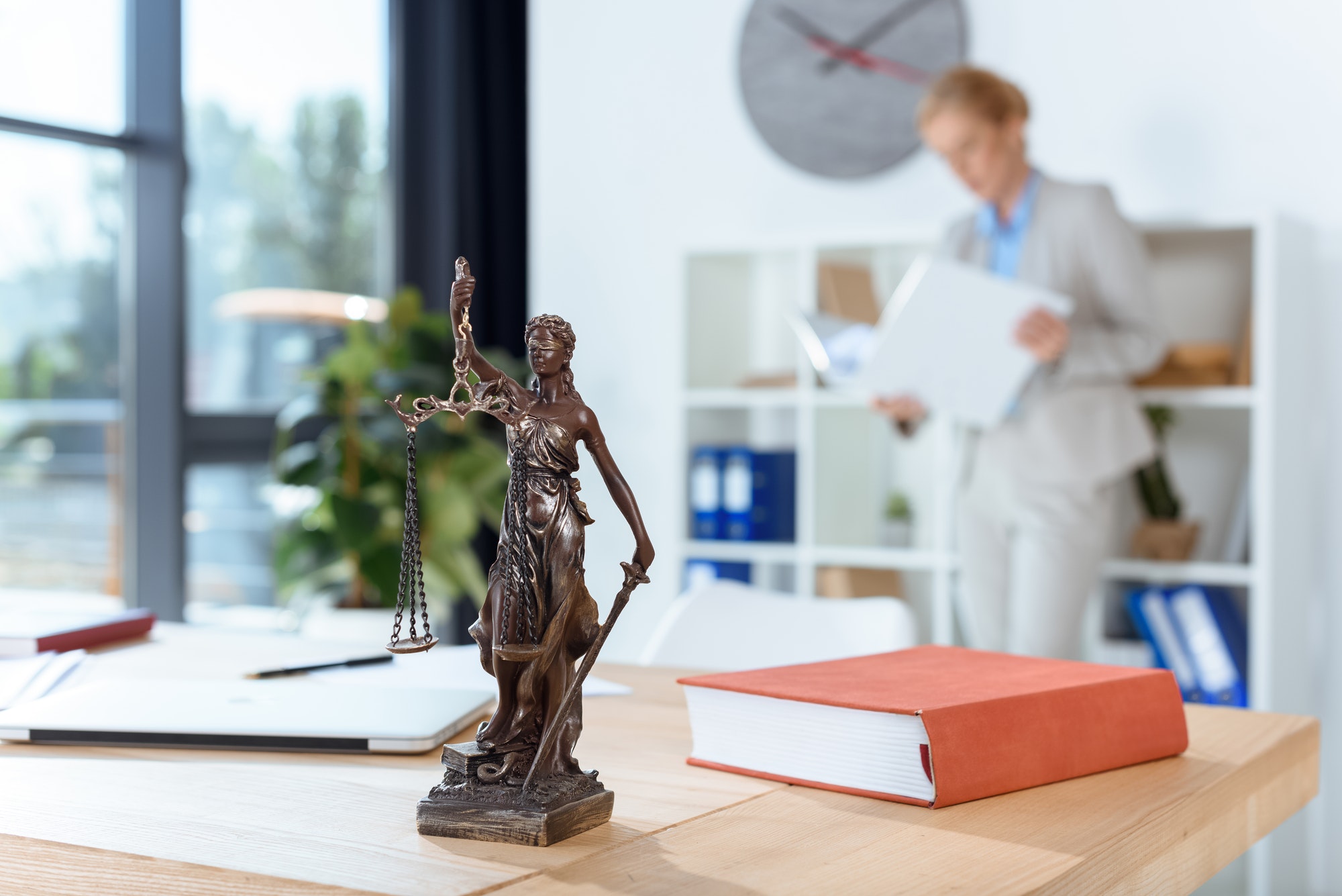 bronze themis sculpture on female lawyer table